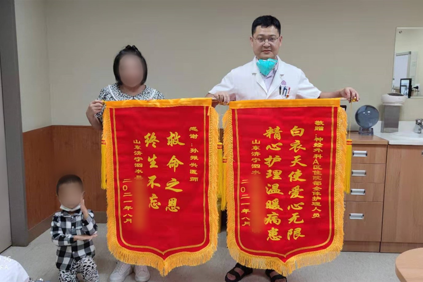 李女士和孩子为孙振兴与护理人员送上锦旗，孩子做出奥特曼出击打怪手势.jpg